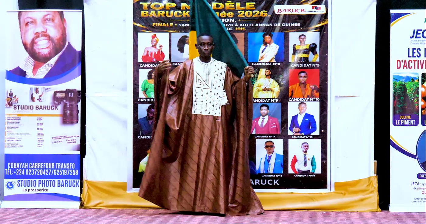 Le candidat n°11 en boubou brun à motifs, sur le podium