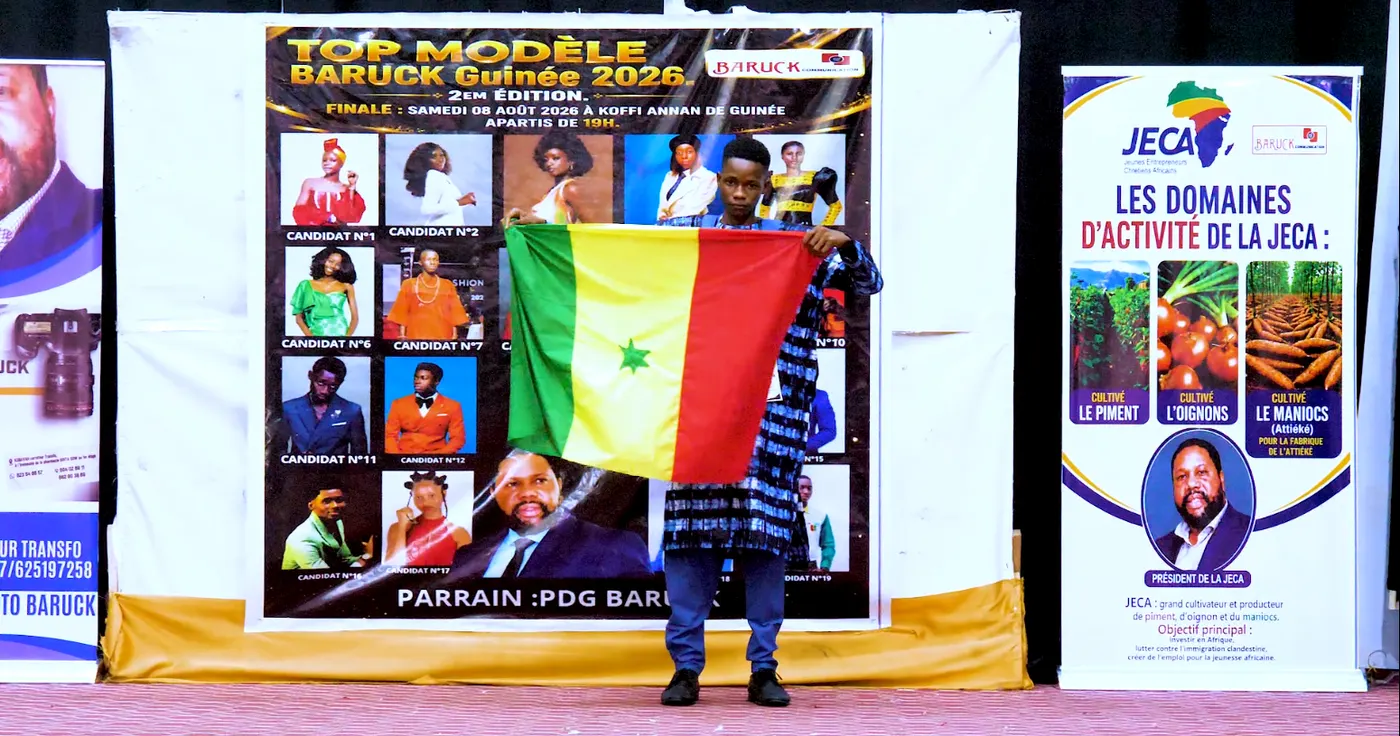 Le candidat n°13 tenant un drapeau vert, jaune et rouge devant lui